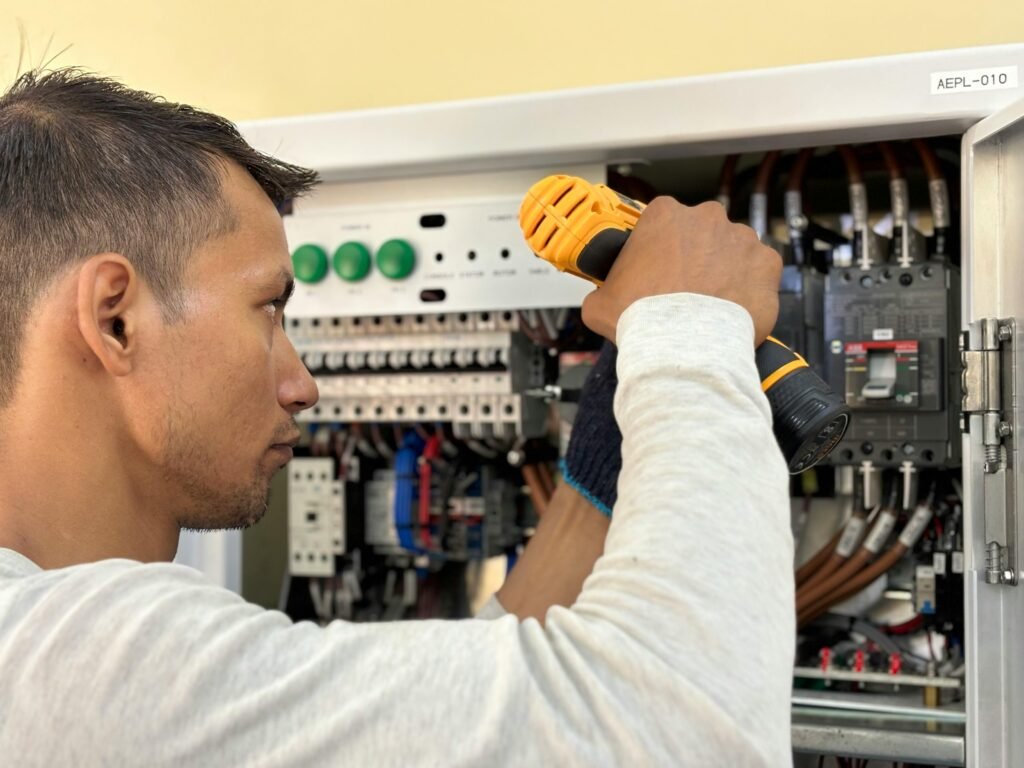 pexels-photo-27928762-27928762 Professional electrician using a drill on an indoor circuit breaker panel.